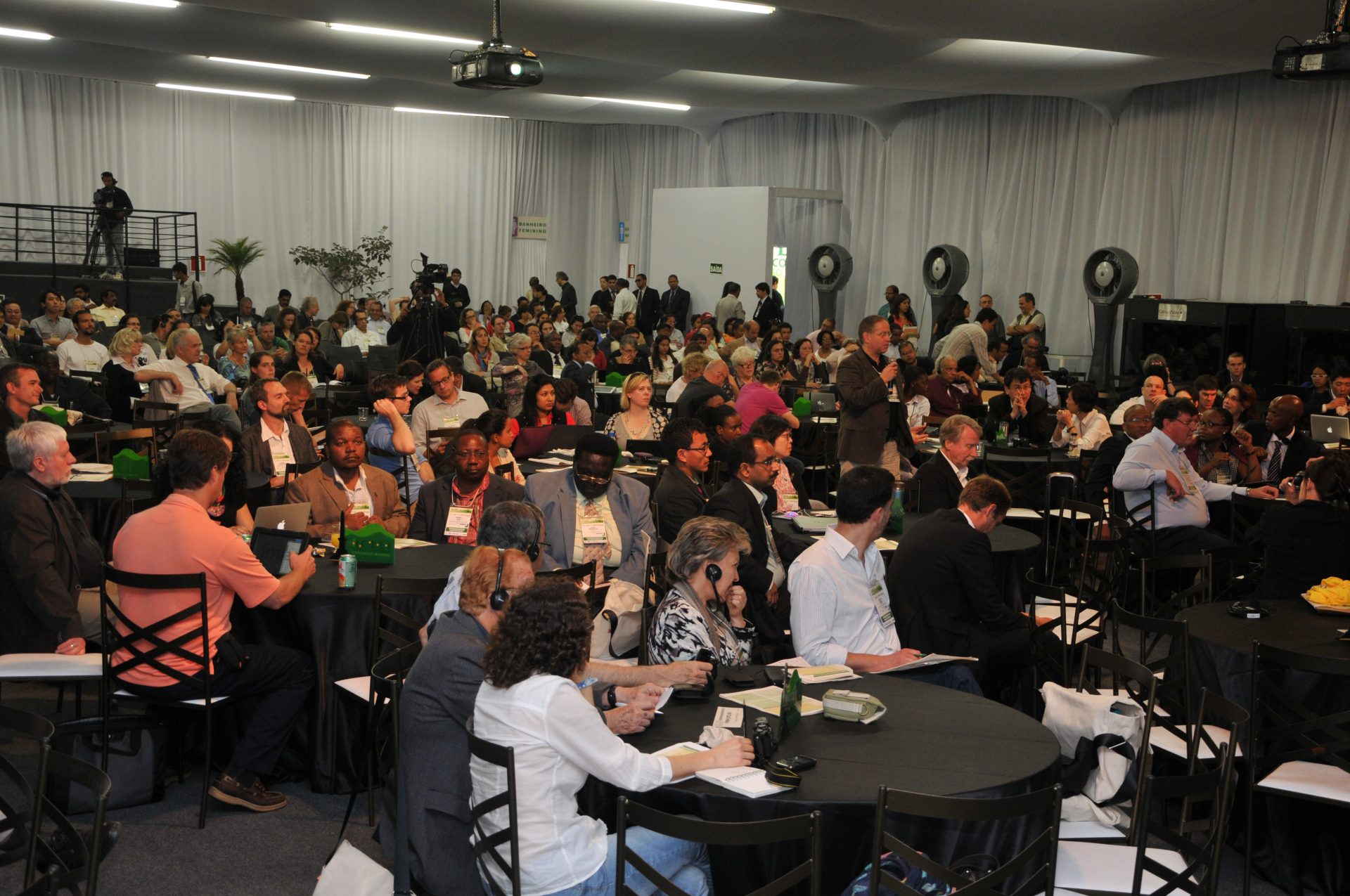 Image of the ICLEI World Congress audience sitting at round tables and waiting for the panel to start.