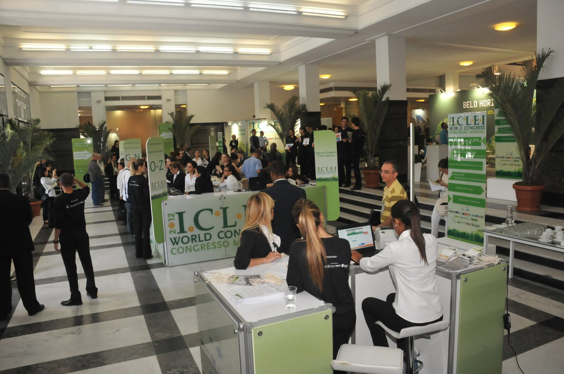 Image of the ICLEI World Congress 2012 tradeshow booth area, showcasing vibrant green signage and cheerful attendees engaging with the exhibits.