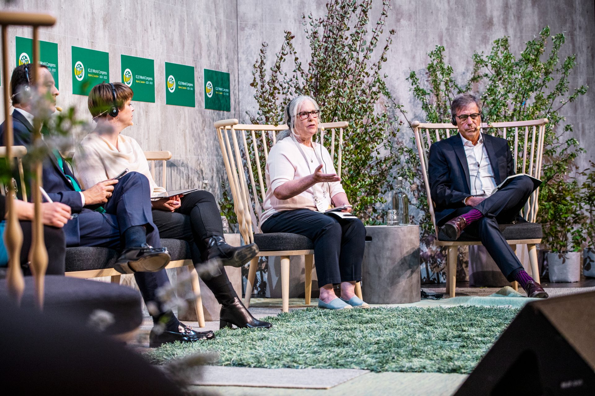 Panelists on stage at the ICLEI World Congress sharing knowledge with the attendees in the audience, the stage is dressed with greenery.